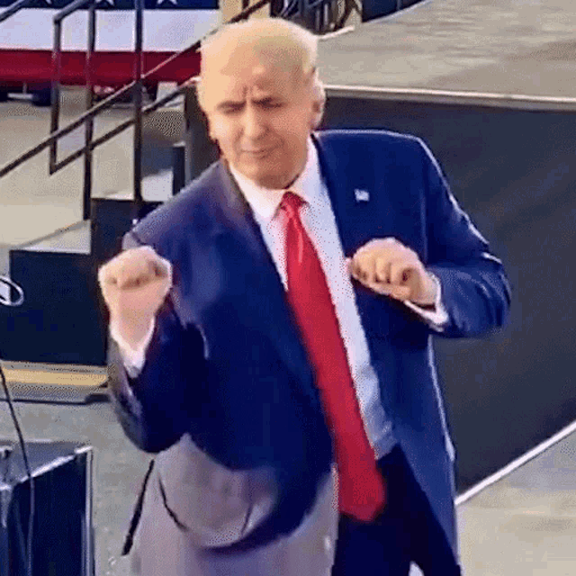 a man in a suit and tie is dancing on a stage