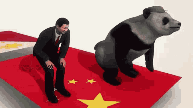 a man in a suit and tie is kneeling next to a panda bear on a chinese flag