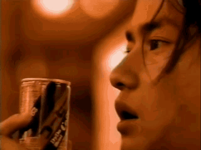 a close up of a person holding a can that says coca cola