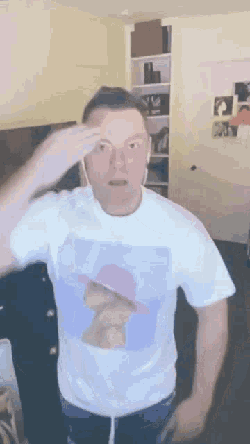 a man wearing a white t-shirt with a picture of a woman in a pink hat
