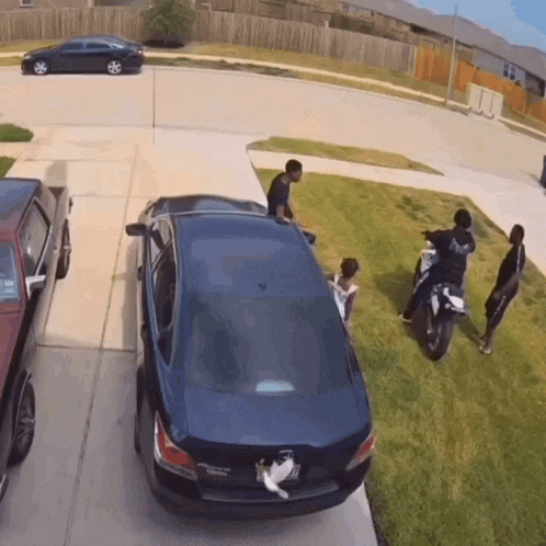 a group of people are standing around a car with a license plate that says acura