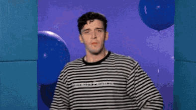 a man in a black and white striped shirt with the word guess on it