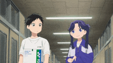 a boy and a girl are standing in a hallway and the boy is holding a box that says yonex