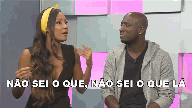 a man and a woman are sitting in front of a pink wall with the words " não sei o que " above them