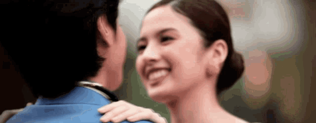 a man and a woman are looking into each other 's eyes and smiling