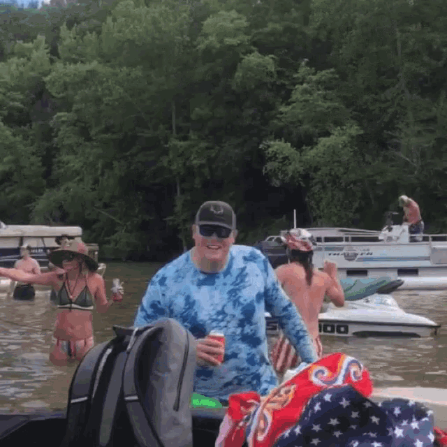 a man in a tie dye shirt stands in front of a boat that says 100 on it