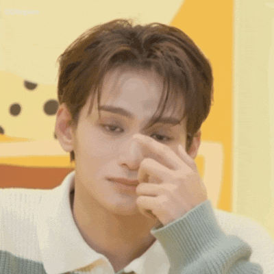 a young man is covering his nose with his hand