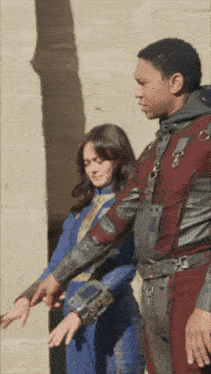 a man and a woman standing next to each other pointing at their hands