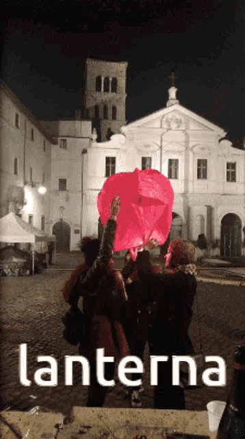 a group of people holding a red lantern in front of a building with the word lanterna on the bottom