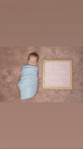 a newborn baby is wrapped in a blue blanket