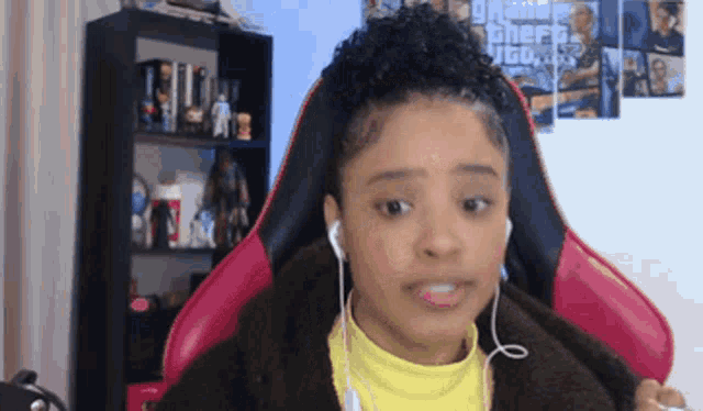 a girl wearing headphones and a yellow shirt is sitting in a pink chair
