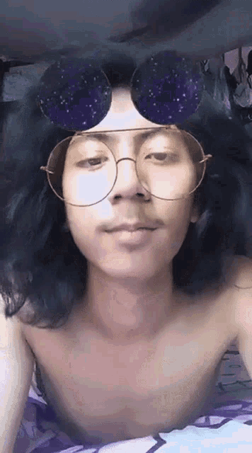 a man without a shirt is wearing a pair of glasses with a starry background