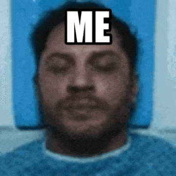a man is laying in a hospital bed with his eyes closed and a sticker on his forehead that says `` me '' .