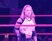 a woman in a wrestling ring is holding a sign that says " do show good "