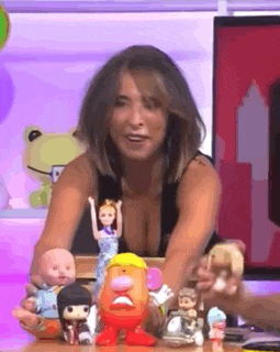 a woman is holding a mr potato head doll and a barbie doll