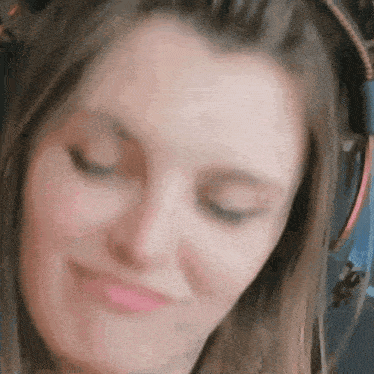 a close up of a woman wearing headphones and making a face .