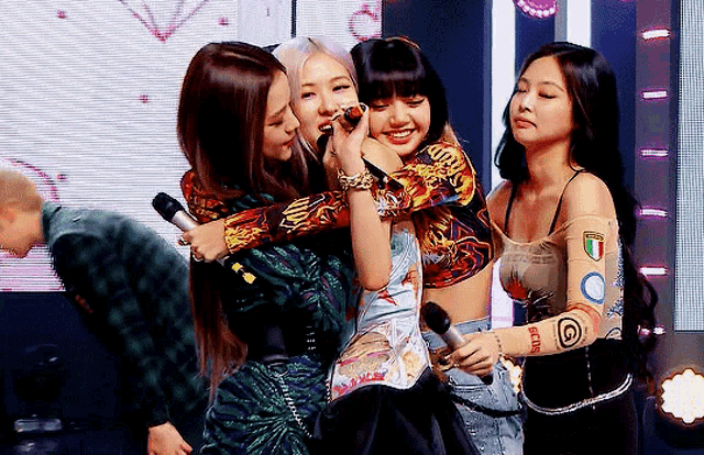 a group of women are hugging each other and one of them is wearing a shirt that says gucci on it