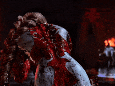 a woman in a bloody costume is standing in front of fire