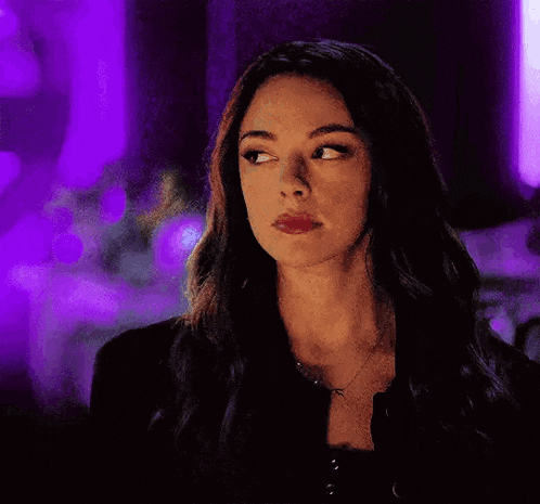 a woman with her eyes closed is wearing a black jacket .