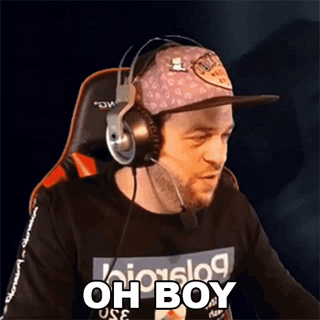 a man wearing headphones and a hat is saying oh boy .