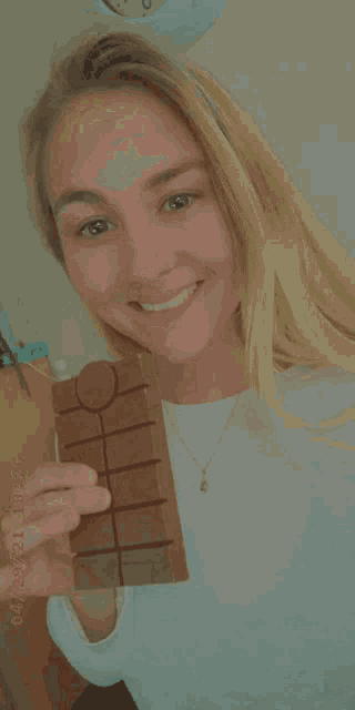 a woman is holding a bar of chocolate in her hand with a date stamp of 04/21