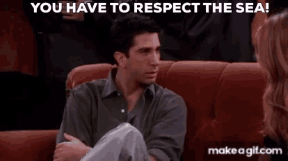 a man is sitting on a couch talking to a woman and says `` you have to respect the sea '' .