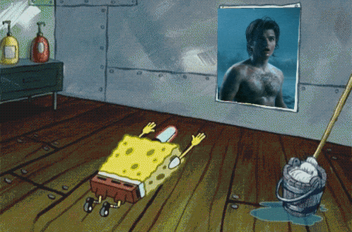 a cartoon of spongebob laying on the floor in front of a picture of a shirtless man