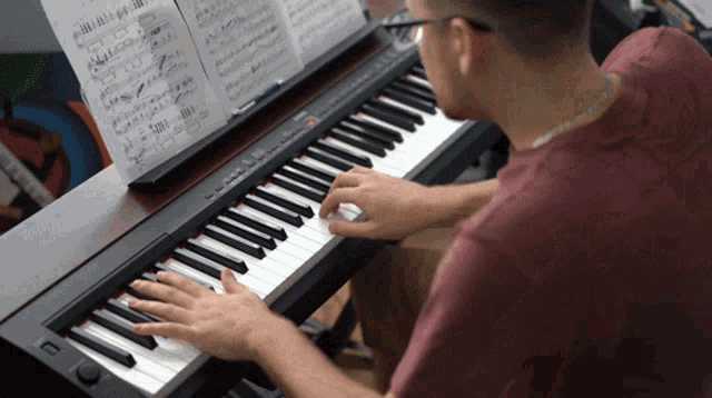 a man is playing a piano with a sheet of music in the background