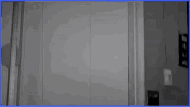 a black and white photo of a man standing in a doorway with the word fellas written on it .