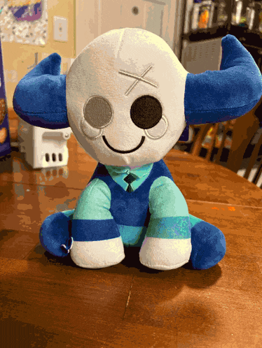 a stuffed animal with blue horns and a cross on its face