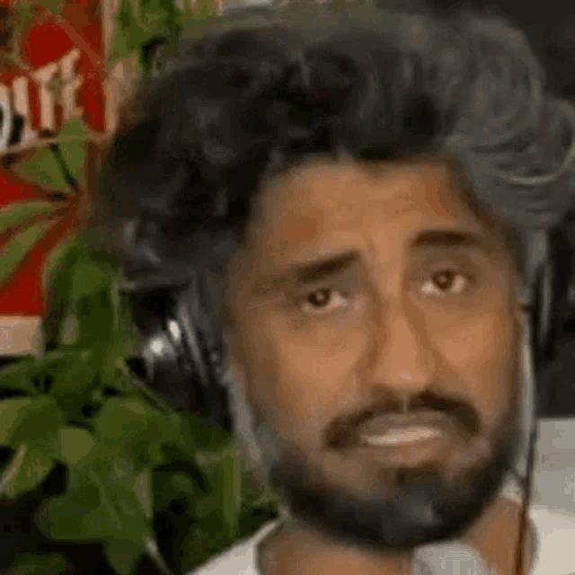 a man with a beard and headphones is wearing a wig .