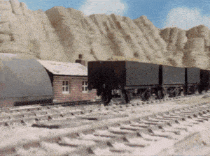 a train is going down the tracks near a small building