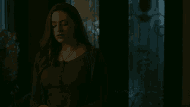 a woman stands in a dark room with the name tony solomons at the bottom