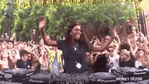 a dj is playing music in front of a crowd of people at a party .