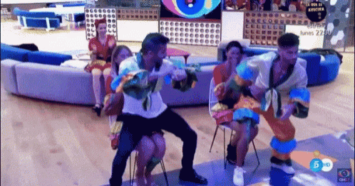 a group of people are dancing in a room with a couch in the background