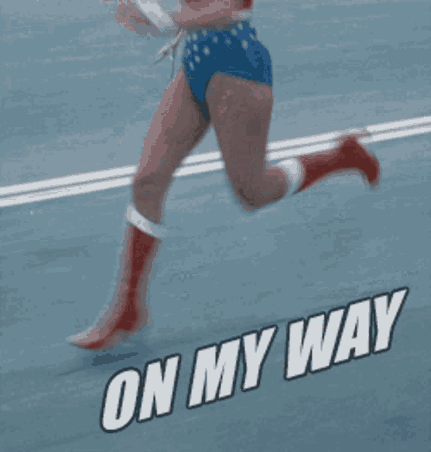 a woman in a wonder woman costume is running down a road