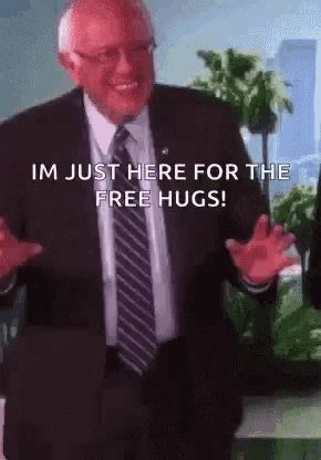 a man in a suit and tie is saying i 'm just here for the free hugs .