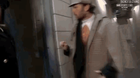 a man in a suit and hat is standing next to another man in a hat ..