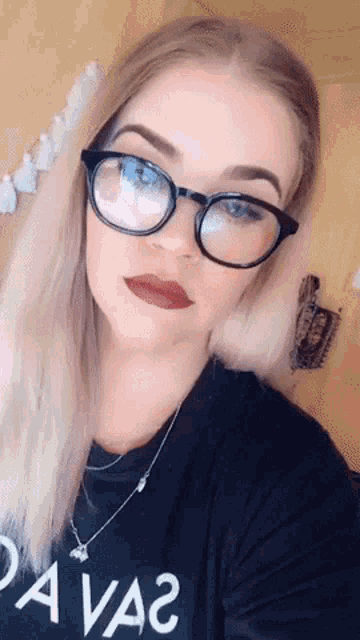 a woman wearing glasses and a shirt that says " da va2 "