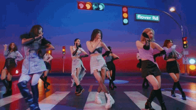 a group of women dancing in front of a sign that says flower rd