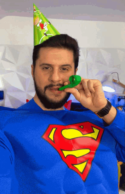 a man wearing a superman costume and a party hat