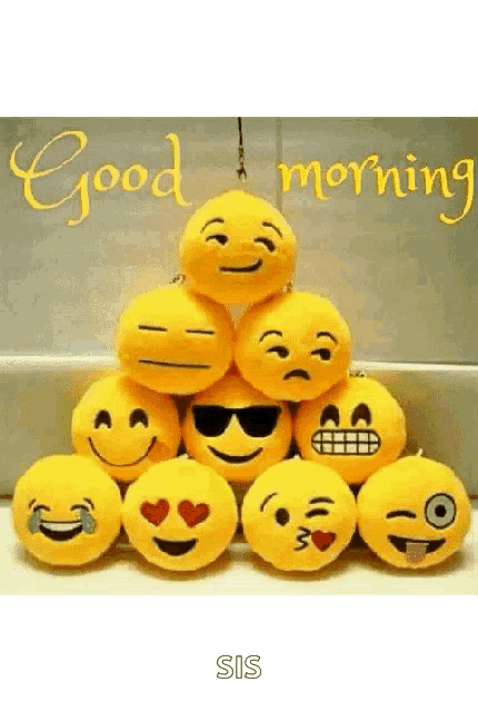 a bunch of stuffed smiley faces are stacked on top of each other with the words `` good morning '' written above them .