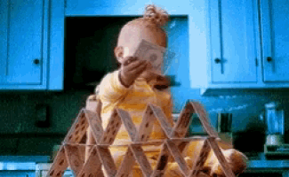 a baby is sitting in front of a stack of playing cards