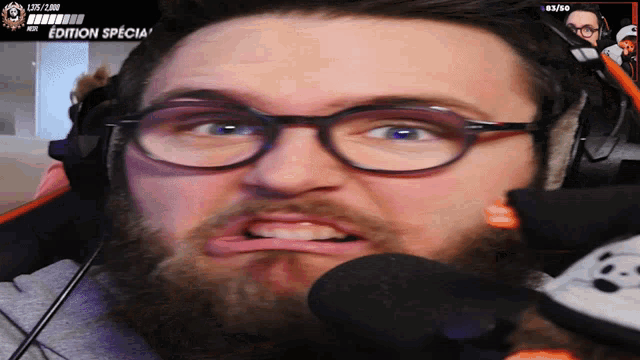 a man wearing glasses and headphones is making a funny face in front of a screen that says edition special
