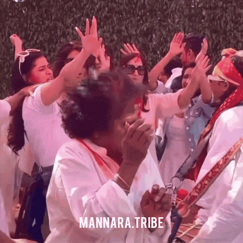 a group of people are dancing in front of a sign that says mannara.tribe