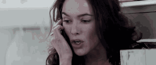 a woman is talking on a cell phone in a kitchen .