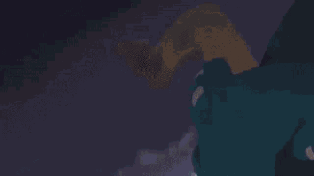 a person is holding a sword with a blue light coming out of it in a dark room .