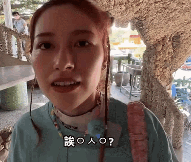 a woman in a blue shirt with chinese writing on her face