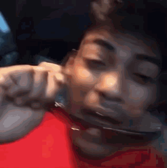 a man is holding a pair of sunglasses in his mouth .