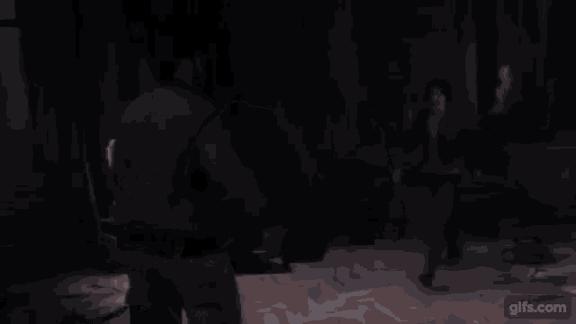 a man and woman are standing in a dark room .